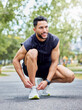 © Nicholas F/peopleimages.com - And even if I stumble, I will get back up and go. Shot of a sporty young man tying his laces while exercising outdoors.