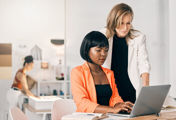 Poster - She knows just what to look for. Shot of a two businesswomen using a laptop together at work.