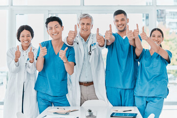Poster - As confident as they are capable. Portrait of a group of medical practitioners showing thumbs up together in a medical office.