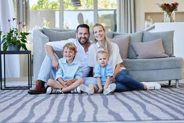 Wall Mural - The white picket fence is outside. Full length portrait of an affectionate mature couple and their kids sitting in the living room at home.