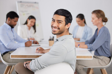 Canvas Print - Care to join us. Cropped portrait of a handsome young businessman sitting in the boardroom during a meeting with her colleagues.