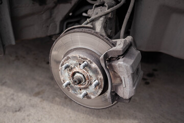Poster - Disc brake of the vehicle for repair, in process of new tire replacement. Car brake repairing in garage.Suspension of car for maintenance brakes and shock absorber systems. Replacement of brake pads.