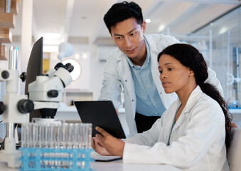 Poster - Double the brain power. Shot of two lab techs working together while using a digital tablet.