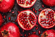 Pomegranate with water drops on a dark background. Generative AI