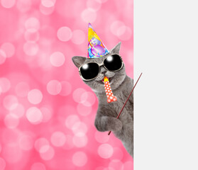 Poster - Happy cat wearing party cap and sunglasses blows in party horn and points away on empty white banner. Shade trendy color of the year 2023 - Viva Magenta background. Empty space for text