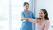 © NanSan - Asian Chinese female physiotherapist caregiver helping elderly woman exercise for recovery, prevention of osteoarthritis and osteoporosis.
