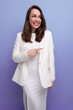 © Ivan Traimak - close-up portrait of a smiling european brunette woman with long hair in a white dress and jacket posing on a studio background