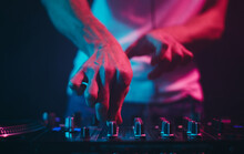 Hands Of A DJ Adjusting Volume Frequency Regulators On A Sound Mixer. Professional Disc Jockey Playing Music On A Party In Night Club