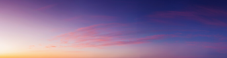 panorama of heavens at dawn. clouds in red and orange colors of a rising sun on a blue sky