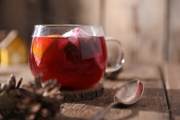 Poster - Tea with herbs, berries and fruits in a transparent cup on a wooden background