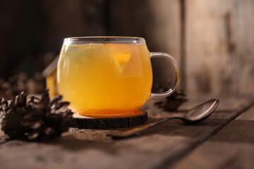 Poster - Tea with herbs, berries and fruits in a transparent cup on a wooden background