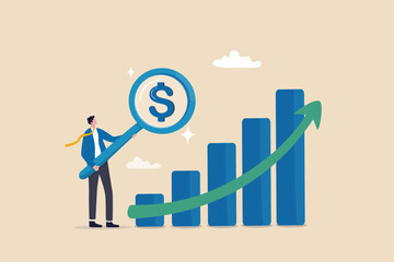 Revenue or salary increase, growth investment profit or earning from stock market, money or wages growing concept, businessman with magnifying glass on dollar money sign with growth graph and chart.