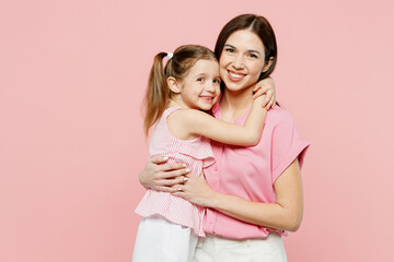 Wall Mural - Happy smiling satisfied woman wear casual clothes with child kid girl 6-7 years old. Mother daughter hugging cuddling look camera isolated on plain pastel pink background. Family parent day concept.