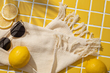 Lemon Slices, Sunglasses And A Wool Scarf Arranged On Yellow Mosaic Tiles Background. Lemon (Citrus Limon) Can Help Improve Immune System. Top View