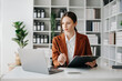 © Nuttapong punna - Business woman using tablet and laptop for doing math finance on an office desk, tax, report, accounting, statistics, and analytical research concept in office