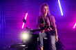 80s style woman on motor scooter with camera in purple studio