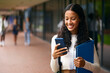 © Monkey Business - Female Secondary Or High School Student Outdoors At School Going To Class Looking At Mobile Phone