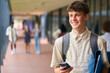 © Monkey Business - Portrait Of Male Secondary Or High School Student Outdoors At School With Mobile Phone