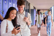 © Monkey Business - Male And Female Secondary Or High School Students Outdoors At School Looking At Mobile Phone
