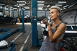 © Viacheslav Yakobchuk - Young woman is standing among cars in car repair shop