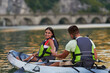 © .shock - A young couple enjoying an idyllic kayak ride in the middle of a beautiful river surrounded by forest greenery