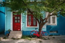 A Blue House With Green Door Has A Red Bicycle With Cherry-filled Basket & A Tree In Front. Generative AI