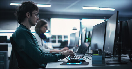 Fototapete - Portrait of a Thoughtful Engineer Working on Desktop Computer in a Technological Office Environment. Research and Development Department Writing Software Code for an Innovative Internet Project