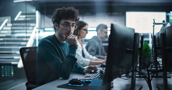 Young Handsome Software Developer Working on Computer in a Technological Laboratory Environment. IT Programming Department Tirelessly Researching and Developing Advanced Commercial Internet Products