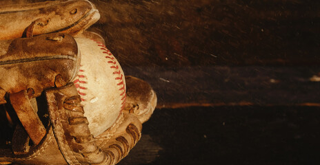 Canvas Print - Wet baseball in glove closeup with wood background, rain game concept.