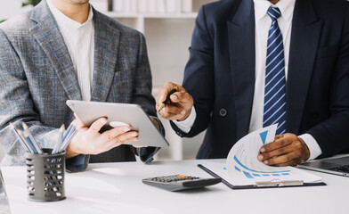 Financial analysts analyze business financial reports on a digital tablet planning investment project during a discussion at a meeting of corporate showing the results of their successful teamwork.