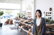 © Trinette Reed - Portrait of Asian small business woman owner in clothing retail store. Generative AI.