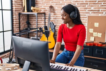 Sticker - Young african american woman musician playing piano keyboard at music studio