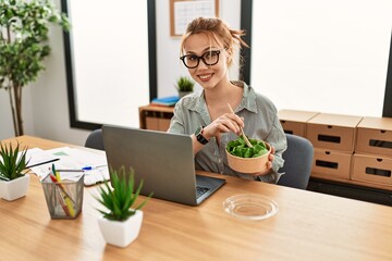 Poster - Young caucasian woman business worker using laptop eating salad at office