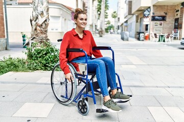 Wall Mural - Young woman smiling confident sitting on wheelchair at street