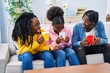 © Krakenimages.com - African american friends drinking coffee sitting on sofa at home