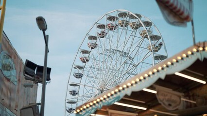 Wall Mural - People having fun riding roller coaster ferris wheel at the amusement park on a sunny day