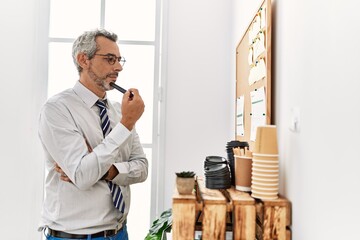 Wall Mural - Middle age grey-haired man business worker reading cork board paper at office