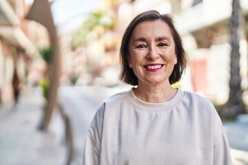 Wall Mural - Middle age woman smiling confident standing at street