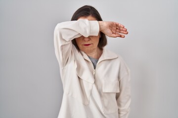 Canvas Print - Middle age hispanic woman standing over isolated background covering eyes with arm, looking serious and sad. sightless, hiding and rejection concept