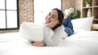 © Krakenimages.com - Young beautiful hispanic woman hugging pillow lying on bed at bedroom