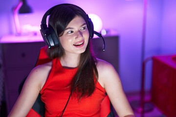 Wall Mural - Young caucasian woman streamer smiling confident sitting on table at gaming room