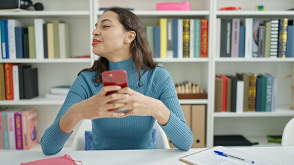 Poster - Young beautiful hispanic woman student using smartphone at university classroom