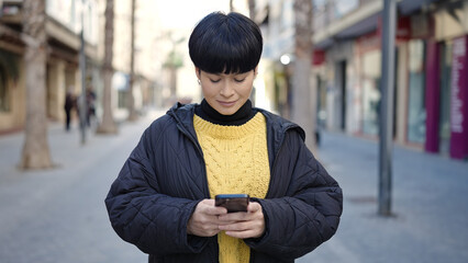 Sticker - Young chinese woman smiling confident using smartphone at street