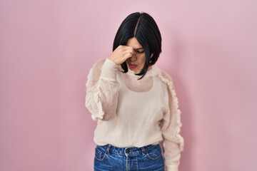 Poster - Young asian woman standing over pink background tired rubbing nose and eyes feeling fatigue and headache. stress and frustration concept.