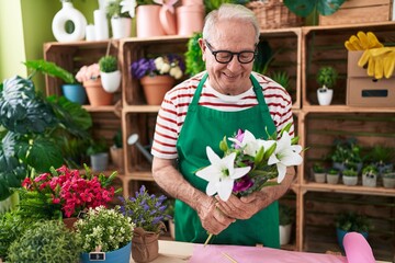 Poster - Middle age grey-haired man florist holding bouquet of flowers at flower shop