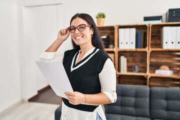 Wall Mural - Young beautiful hispanic woman business worker reading document at office