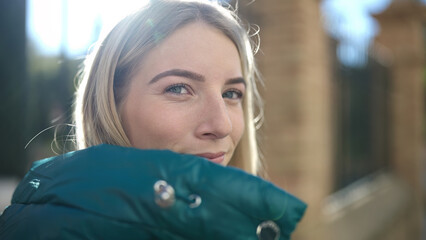 Poster - Young blonde woman standing with serious expression at street