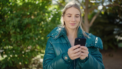 Poster - Young blonde woman using smartphone at park