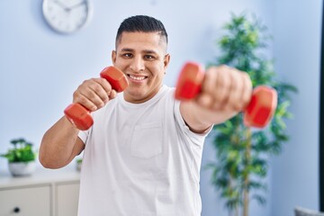 Poster - Young latin man smiling confident using dumbbells boxing at home