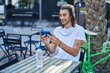 © Krakenimages.com - Young hispanic man watching video on smartphone sitting on table at coffee shop terrace